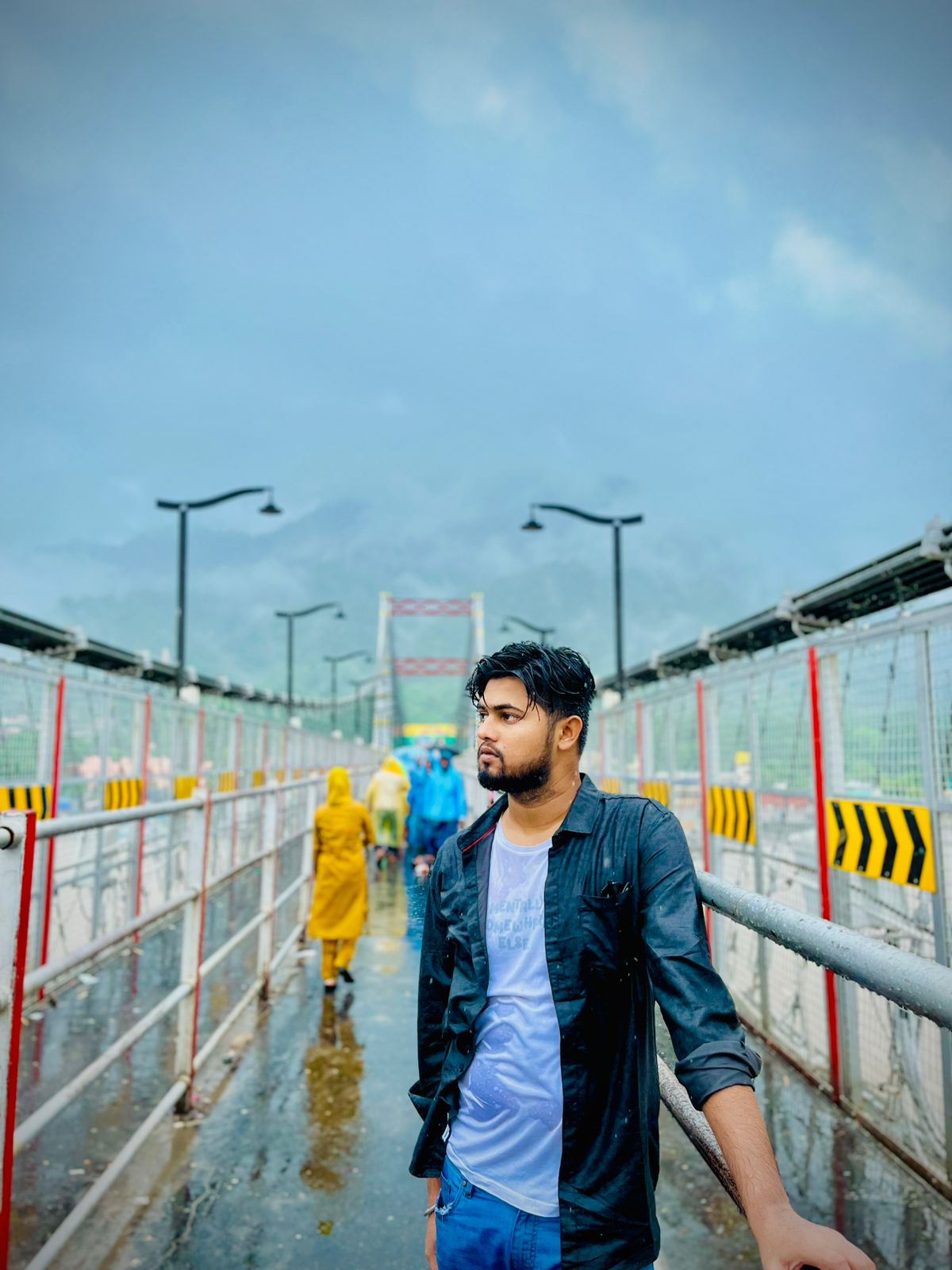 Niraj Aarya on a rainy bridge walkway